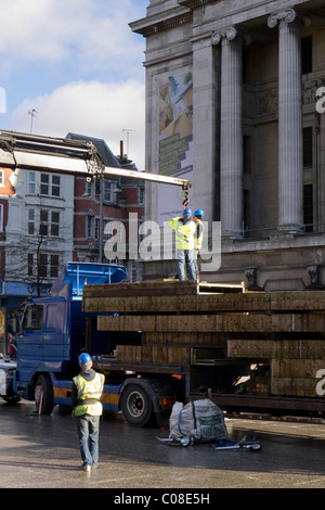 Operai lavorano con una gru e il carrello per preparare nottingham piazza del mercato per la fiera del divertimento a scuola a metà termine febbraio 2011 Foto Stock