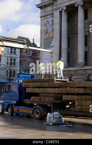 Operai lavorano con una gru e il carrello per preparare nottingham piazza del mercato per la fiera del divertimento a scuola a metà termine febbraio 2011 Foto Stock