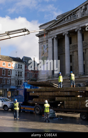 Operai lavorano con una gru e il carrello per preparare nottingham piazza del mercato per la fiera del divertimento a scuola a metà termine febbraio 2011 Foto Stock