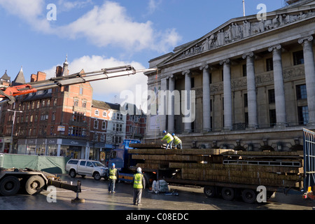 Operai lavorano con una gru e il carrello per preparare nottingham piazza del mercato per la fiera del divertimento a scuola a metà termine febbraio 2011 Foto Stock