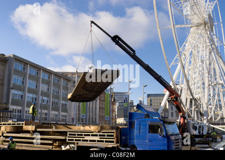 Operai lavorano con una gru e il carrello per preparare nottingham piazza del mercato per la fiera del divertimento a scuola a metà termine febbraio 2011 Foto Stock