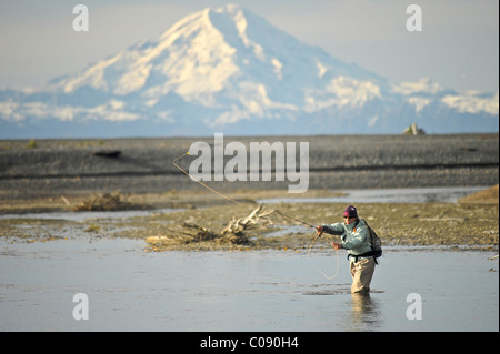 Donna di Pesca a Mosca Report di Pesca per wild Steelhead su Deep Creek con Mt. Redoubt in background, Penisola di Kenai, centromeridionale Alaska Foto Stock