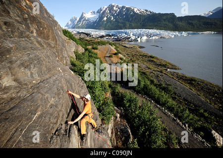 L'uomo arrampicata su roccia con Spencer ghiacciaio in background, Chugach National Forest, Penisola di Kenai, centromeridionale Alaska, estate Foto Stock