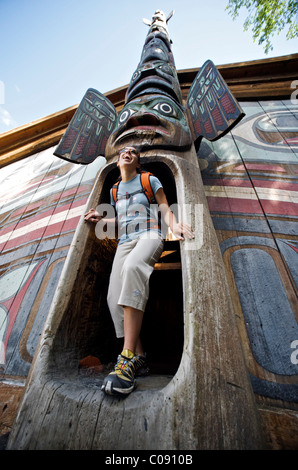 Donna esplora il clan casa di Totem Bight State Historical Park vicino a Ketchikan, a sud-est di Alaska, estate Foto Stock