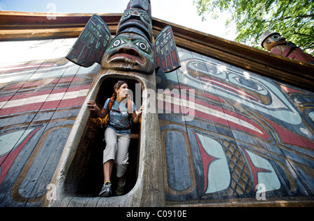 Donna esplora il clan casa di Totem Bight State Historical Park vicino a Ketchikan, a sud-est di Alaska, estate Foto Stock