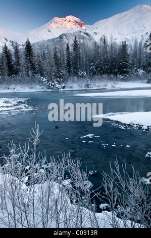 Prima la luce colpisce un picco nella valle di Portage, Chugach National Forest, centromeridionale Alaska, inverno Foto Stock