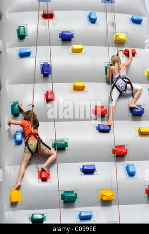 I bambini la pratica su un gonfiabile parete di arrampicata Foto Stock