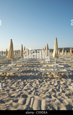 Ombrelloni e sedie a sdraio sulla spiaggia di mattina Foto Stock