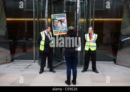 Una solitaria i diritti degli animali protester sorge al di fuori degli uffici del francese AXA Insurance Company. Foto Stock