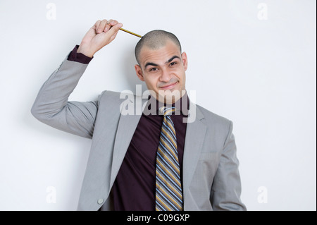 Imprenditore di graffiare la sua testa con una matita Foto Stock