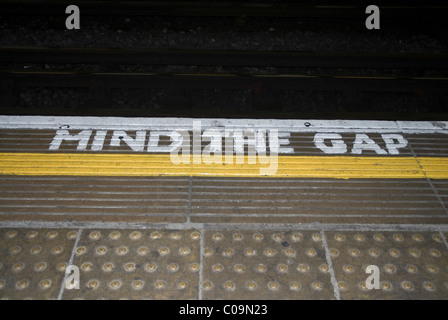 Mente il divario, una frase scritta su una stazione metropolitana a piattaforma in West London REGNO UNITO Foto Stock