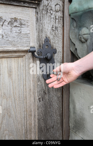 Apertura a mano un vecchio rovere massiccio castello porta al castello rinascimentale Kronborg, Danimarca, con una enorme chiave Foto Stock