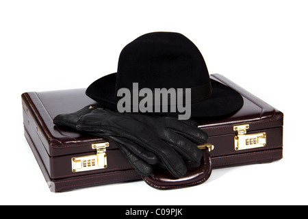 Valigia con posa da sopra un cappello e dei guanti di protezione su sfondo bianco Foto Stock