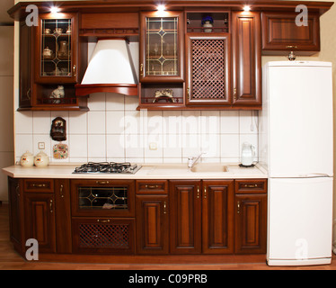 Cucina moderna in un interno con legno эмитацией di razze di prezioso e costruito in illuminazione Foto Stock