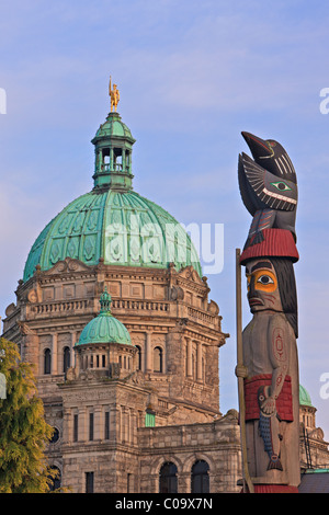 Il totem pole davanti al British Columbia edificio del Parlamento all'interno del porto di Victoria, British Columbia, Canada. Foto Stock