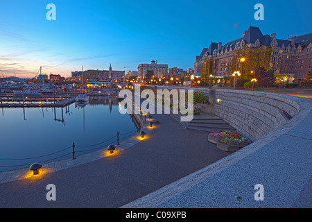 Victoria Harbour con barche a vela e gli illuminati Empress Hotel (Fairmont Hotels) durante il tramonto, crepuscolo, British Columbia Foto Stock