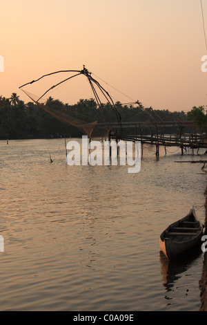 Wooen imbarcazione cinese e reti da pesca nel tramonto, Kerala, India Foto Stock