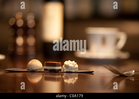 Cioccolatini di lusso tartufo su una tabella con la blurb tazza di caffè e vino in massa posteriore Foto Stock