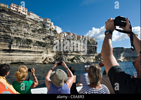 Fotocamera wielding i turisti a bordo di una gita in barca attorno a Bonifacio. La Corsica. Francia Foto Stock