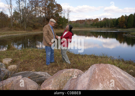 Giocoso coppia di anziani in piedi da un lago. Foto Stock
