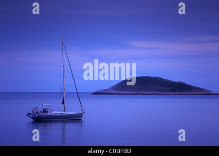 Barca a vela ormeggiata in tranquilla baia. Mar Mediterraneo - costa adriatica, Croazia, Hvar, Sveti Klement. Foto Stock