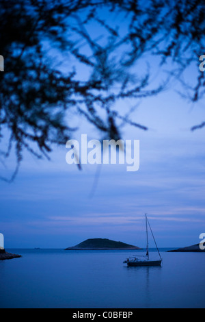 Barca a vela ormeggiata in tranquilla baia. Mar Mediterraneo - costa adriatica, Croazia, Hvar, Sveti Klement. Foto Stock