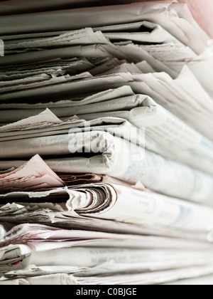 Vecchio giornale accatastati in pile per il riciclaggio. Studio shot con messa a fuoco selettiva e spazio di copia Foto Stock