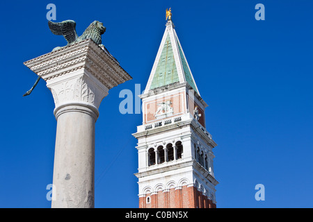 Basso angolo di visione del Leone di San Marco e Campanile o torre campanaria in piazza San Marco, Venezia Italia Foto Stock