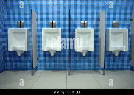 Fila di orinatoi in una toilette pubblica Foto Stock