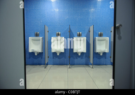 Fila di orinatoi in una toilette pubblica Foto Stock