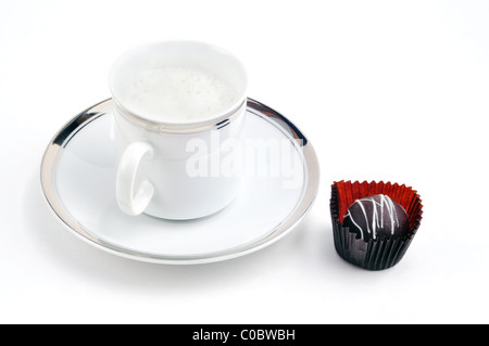 Pomeriggio indulgenza: caffè cappuccino o latte servita in fantasia rivestimento della Gold Cup e il piattino con il cioccolato. Foto Stock