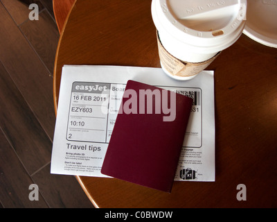 Passaporto di caffè e stampate la carta d'imbarco su un tavolo presso l'Aeroporto Internazionale di Belfast Irlanda del Nord Foto Stock