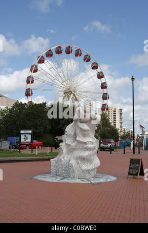 Ruota panoramica dietro lo Scott Memorial nella baia di Cardiff, Galles, Regno Unito Foto Stock