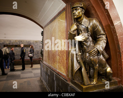 Superstiziosi moscoviti touch per buona fortuna il naso lucido di una statua di un cane a Ploshchad Revolyutsii la stazione della metropolitana di Mosca Foto Stock