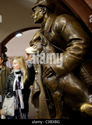 Superstiziosi Muscovite tocca per buona fortuna il naso di una statua di un cane a Ploshchad Revolyutsii la stazione della metropolitana di Mosca Foto Stock