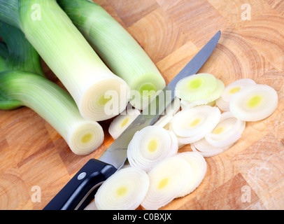 I porri su un tagliere di legno concentrarsi su i porri tagliati a fettine Foto Stock