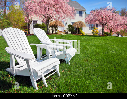 Poltrone Adirondack seduti sul prato davanti generico stile coloniale New England house Foto Stock