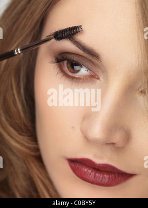 Licenza disponibile a MaximImages.com - Closeup di un volto di donna con il trucco che è applicato alle sue sopracciglia Foto Stock