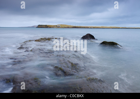 Rallentare la velocità dello shutter foto del molo roccioso sulla spiaggia Staffin, Isola di Skye, Ebridi, Highlands scozzesi Foto Stock