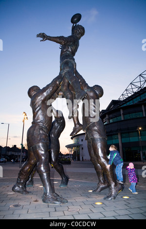 I bambini salire e giocare on line-out scultura dello scultore Gerald Laing fuori lo stadio di rugby di Twickenham, Inghilterra. Regno Unito. Foto Stock