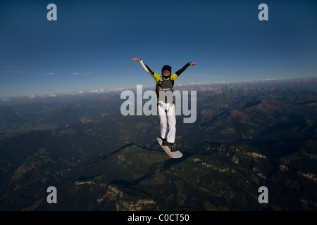 Uomo sulla scheda di sky è volare sulle montagne nel cielo blu. Foto Stock