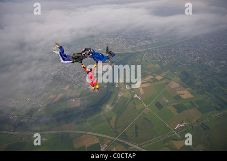 Paracadutista Freefly team è la formazione di una speciale formazione di ibridi su una spettacolare scenario cloud nel cielo con 130 km/h. Foto Stock