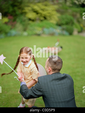 Padre e figlia giocando con la bacchetta della fata Foto Stock