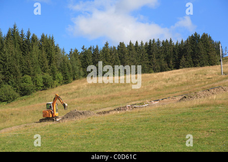 Piccolo lavoro di scavo sul pendio di vivaio ski run Foto Stock