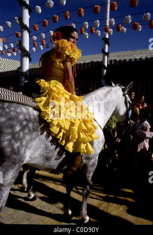 Il Siviglia Fiera di primavera, la Feria de abril de Sevilla, Sevilla , Andalucia,Spagna. Ragazza sul cavallo con il tradizionale abito di flamenco Foto Stock
