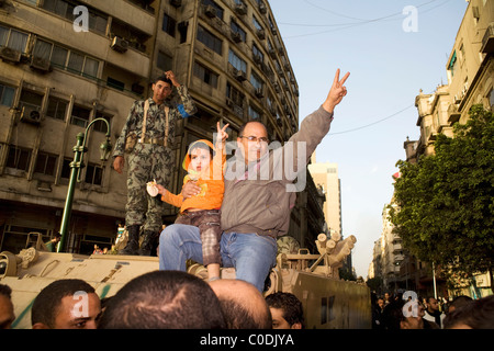 Un uomo e un bambino dà il segno di pace durante le proteste contro il governo del Cairo in Egitto Piazza Tahrir su GEN29, 2011 Foto Stock