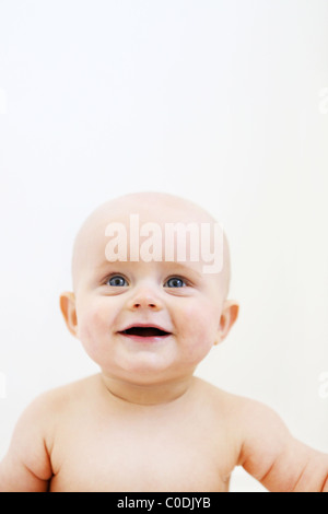 Bald baby davanti a uno sfondo bianco Foto Stock