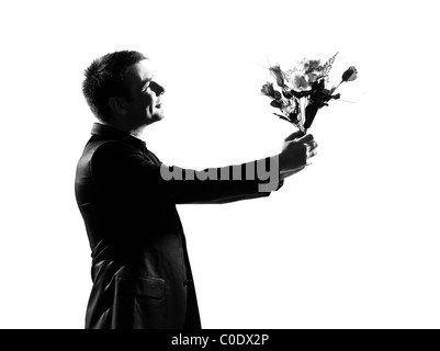 Silhouette caucasian uomo d affari offrendo fiori che esprimono il comportamento di lunghezza completa su studio isolato sfondo bianco Foto Stock