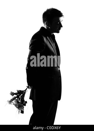 Silhouette caucasian uomo d affari offrendo fiori che esprimono il comportamento di lunghezza completa su studio isolato sfondo bianco Foto Stock