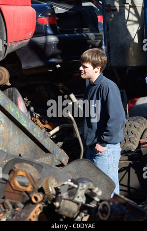 Uomo in auto scrapyard alla ricerca di parti di ricambio Foto Stock